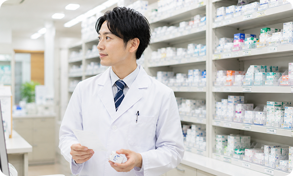 調剤室で薬を確認する男性薬剤師